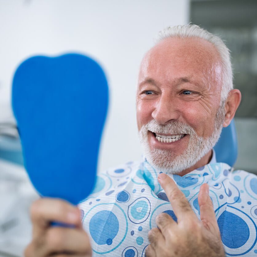 older man smiling at dentist
